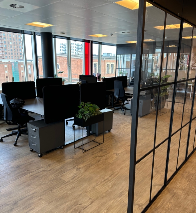 Coworkingområde med new yorkervægge og planter i forgrunden
